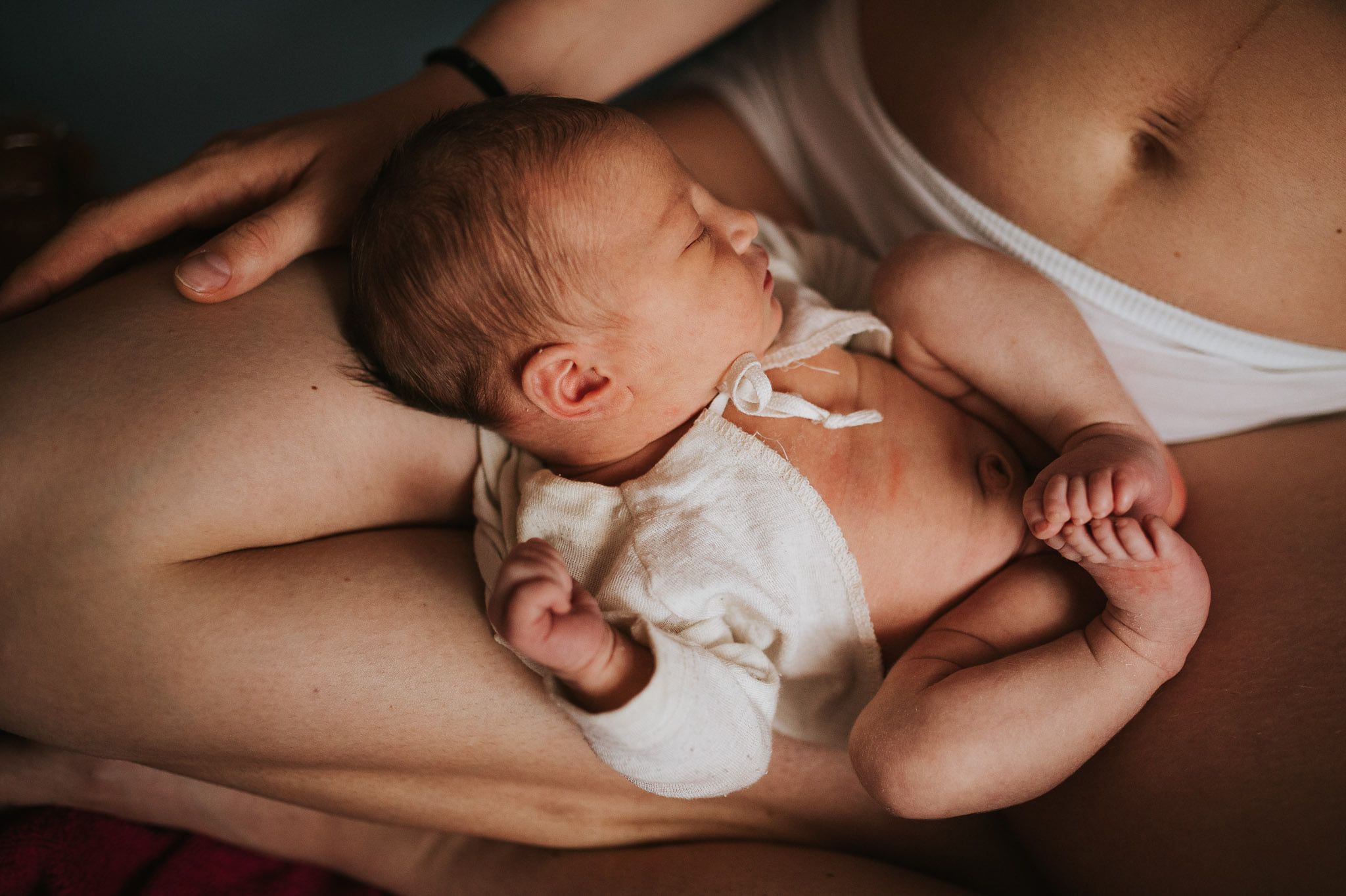 Neugeborenes liegt auf Mamas Schoß - Babyfotos, Neugeborenenfotos, Neugeborenenshooting Klagenfurt