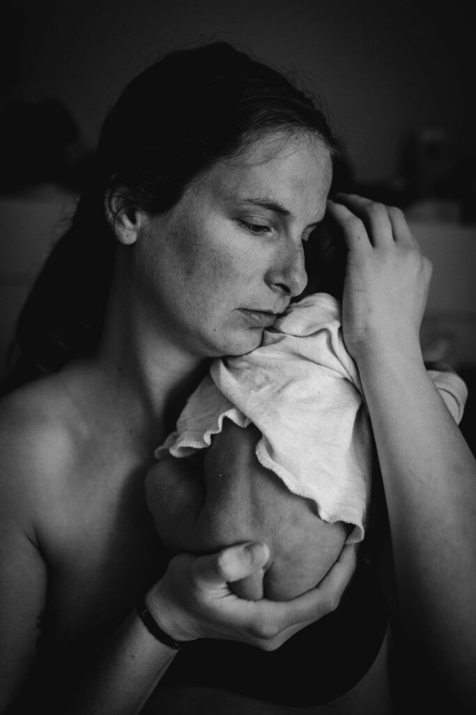 Mama hält Neugeborenes im Arm - Geburtsfotografie Kärnten