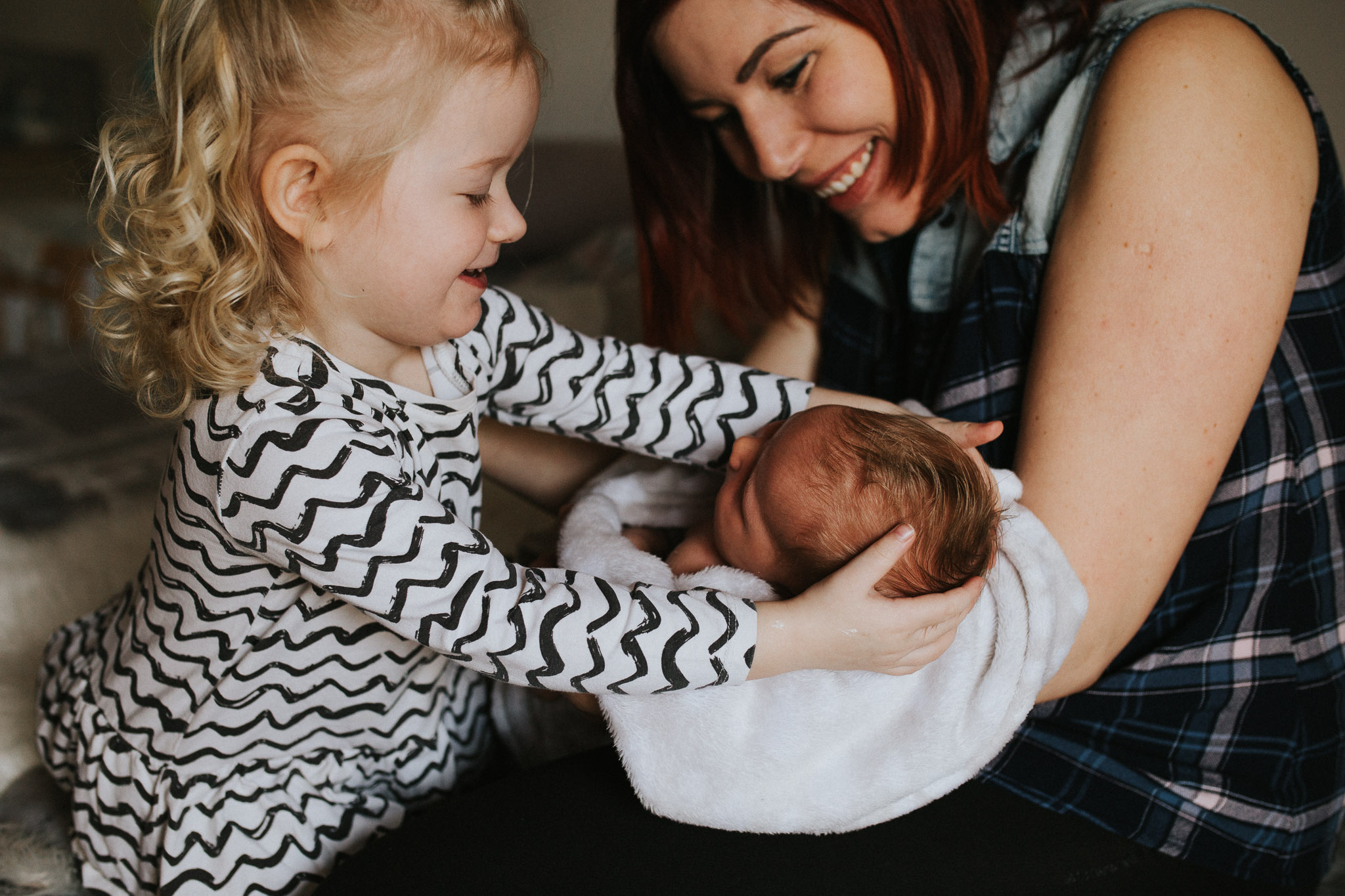 Mama zeigt Baby der großen Schwester - Neugeborenenfotos Klagenfurt