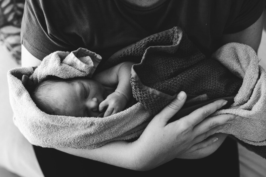 Neugeborenes in Tücher gewickelt kurz nach der Geburt - Geburtsfotografie Kärnten