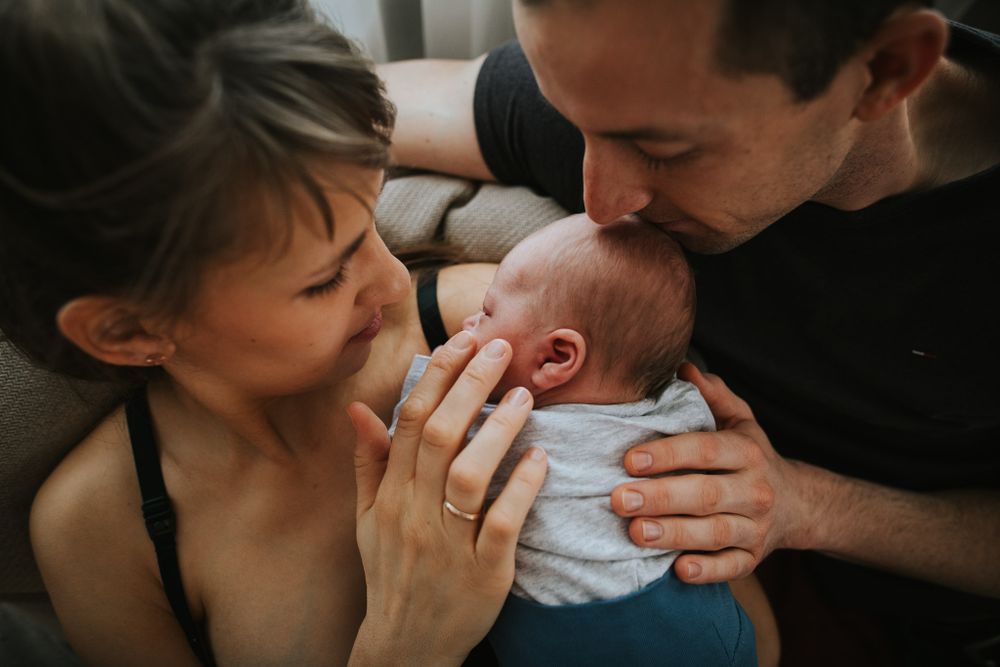 Eltern liebkosen ihr Neugeborenes - Babyfotos, Neugeborenenfotos, Neugeborenenshooting Klagenfurt